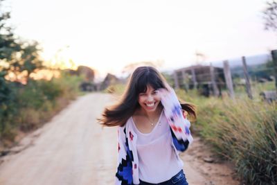 Portrait of smiling young woman against blurred background