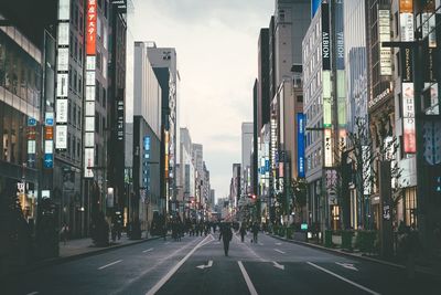 People on road amidst buildings in city