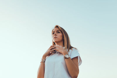 Low angle view of young woman against white background