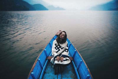 Full length of woman sailing in blue rowboat in river