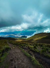 Road leading towards mountains against sky