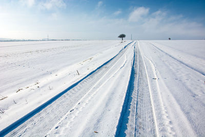 Tire tracks on snow covered road, winter view, eastern poland