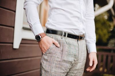 Midsection of well-dressed man standing in park