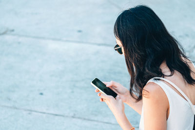 Side view of woman using smart phone on street