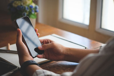 Midsection of man using mobile phone