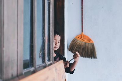 Portrait of a boy standing by window