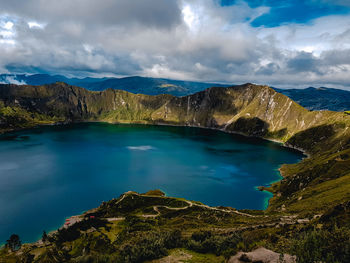 Scenic view of lake by mountains against sky