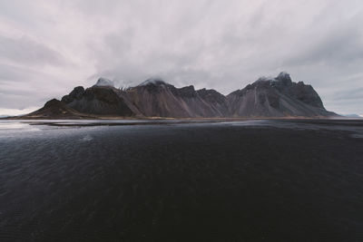 Scenic view of sea and mountains against sky