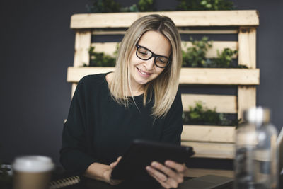 Portrait of smiling young woman using mobile phone