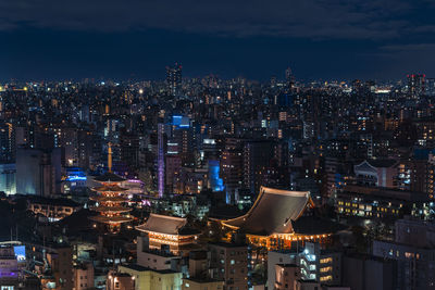 Aerial night panoramic view of buddhist temple halls and pagoda light-up in the asakusa district.