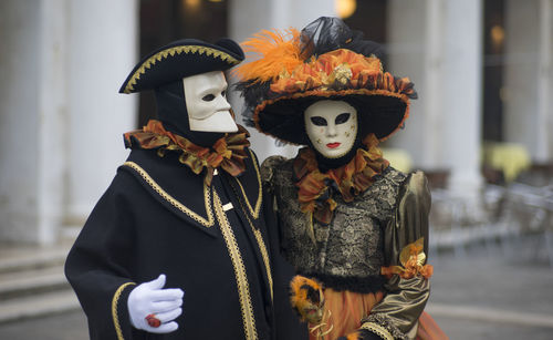 People wearing masks and costumes on street during carnival