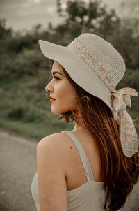 Rear view of woman wearing hat standing outdoors