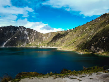 Scenic view of lake and mountains against blue sky