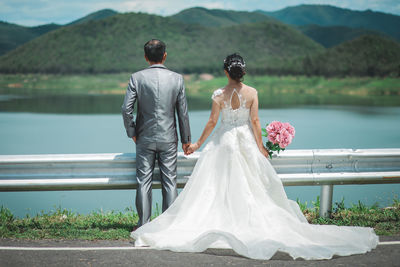 Couple standing against lake