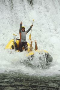 Cheerful man rafting in river