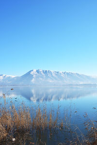 Winter landscape scene with frozen lake, snowy mountain