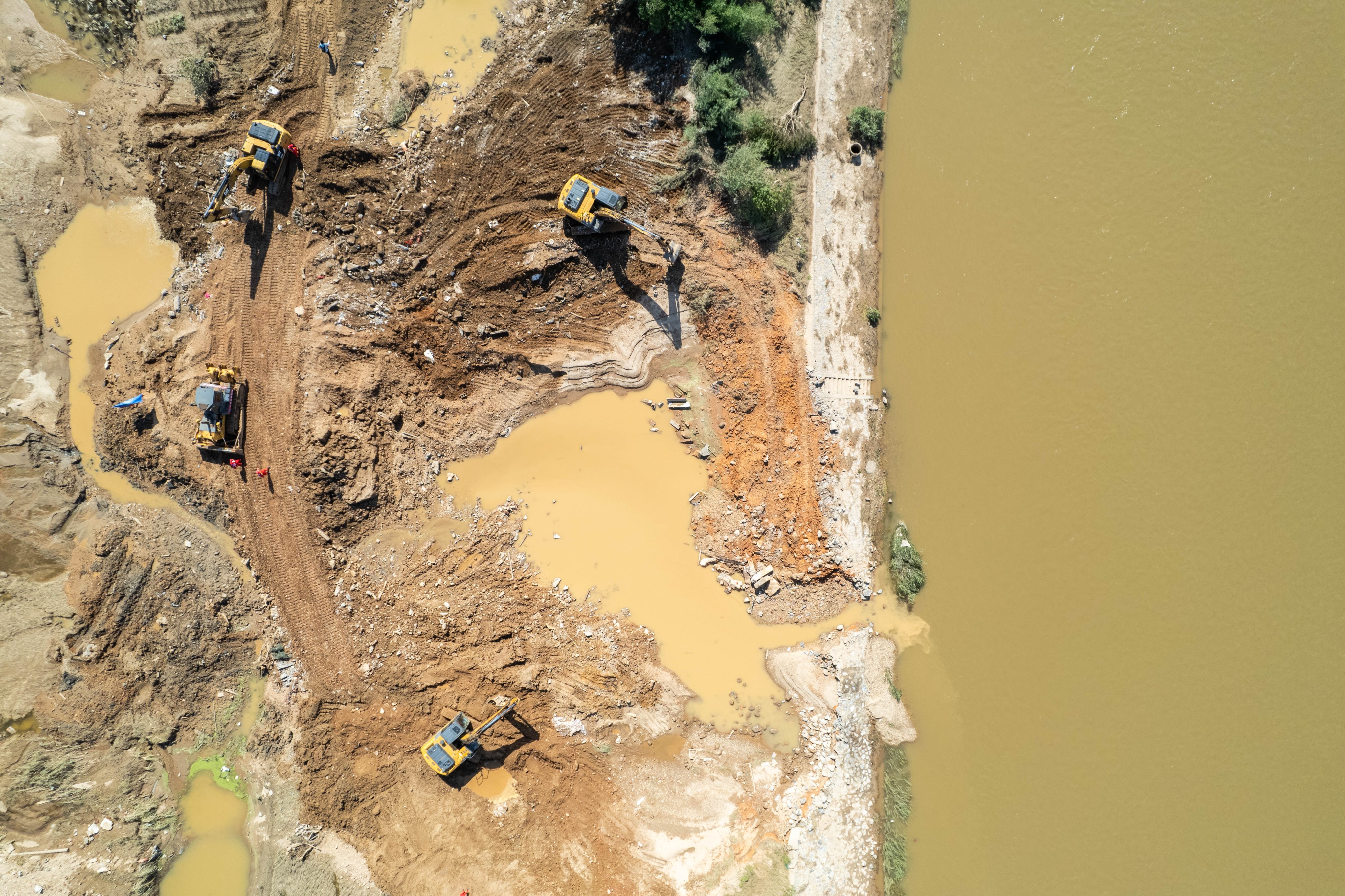 Emergency workers repairing a breached dike in the Juanshui River in central China’s Hunan province on Wednesday. The breach occurred on Sunday after heavy rainfall hit the province. Photo: Xinhua/EPA-EFE