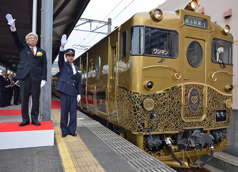 JR九州：デザインを手がけた水戸岡鋭治さん（左）と佐世保駅長の出発合図で動き出す「或る列車」＝長崎県佐世保市で2015年11月1日午前9時54分、梅田啓祐撮影