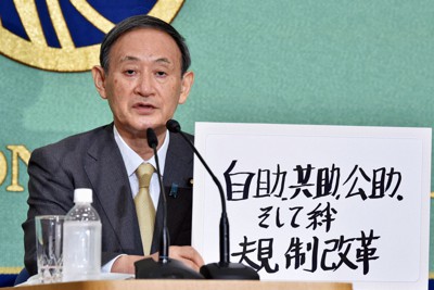 2020年9月の自民党総裁選立候補者討論会で「自助、共助、公助」と書かれたボードを手にする菅義偉氏＝東京都千代田区の日本記者クラブで2020年9月12日午後1時3分、竹内紀臣撮影