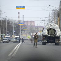 ウクライナ東部のクラマトスルクの道路で、軍用車両の横に立つウクライナ兵＝2022年2月24日、AP