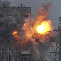 ロシア軍戦車の砲撃を受け爆発する集合住宅＝ウクライナ南東部マリウポリで3月11日、AP