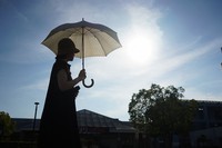 A person walks with an umbrella under the intense sunlight in the town of Hatoyama, Saitama Prefecture in July 2023. (Mainichi/Naoki Watanabe)