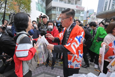 秋田県と四国4県の合同物産展で、購入者にパンフレットを配る佐竹敬久秋田県知事（右）＝東京都千代田区の東京交通会館で2023年11月15日午後0時42分、手塚耕一郎撮影