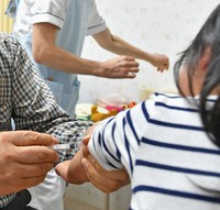 A child is seen receiving an influenza vaccine in this file photo taken in Fukuoka's Higashi Ward. (Mainichi/Takeshi Noda)