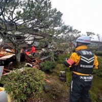 県緊急消防援助隊として倒壊した家屋の捜索活動をする小田さん（右）ら＝大津市提供