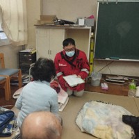 石川県輪島市の避難所で診察にあたる医師の山崎順久さん（右）＝同市で2024年1月5日、大阪赤十字病院提供（画像の一部を加工しています）