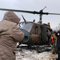 孤立状態となっている地区から陸上自衛隊のヘリで救助される住民ら。悪天候のため1日遅れで約60人が搬送された＝石川県輪島市で2024年1月8日午後3時25分、和田大典撮影