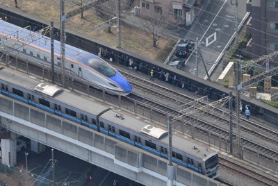 線路上で停車した北陸新幹線から降りて避難する乗客ら＝さいたま市中央区で2024年1月23日午後1時12分、本社ヘリから宮間俊樹撮影