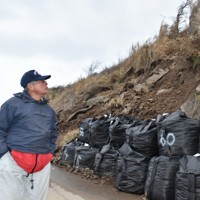 県道に崩落した岩の撤去状況を確かめる大箱洋介さん＝石川県輪島市で2024年3月10日午前9時35分、中尾卓英撮影