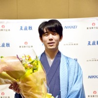 王座戦の初防衛を決め、花束を手に笑顔を見せる藤井聡太王座＝京都市で2024年9月30日午後10時27分、新土居仁昌撮影