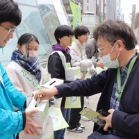 あしなが育英会の奨学生らの募金に応じる男性（右）＝札幌市の札幌駅前で2024年4月20日午後1時6分、片野裕之撮影