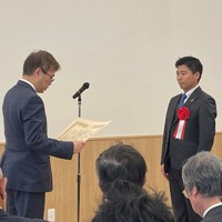 羽生善治日本将棋連盟会長（左）から「将棋の日」表彰を受ける大和証券グループ本社の南泰介宣伝課長＝東京都渋谷区の新将棋会館で2024年11月19日、丸山進撮影