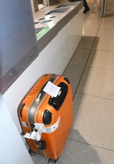 A suitcase with a note with the word "discard" written in Japanese is left near a trash bin at Kansai International Airport in Osaka Prefecture on Aug. 27, 2024. (Mainichi/Tadakazu Nakamura)