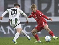 Freiburg's Ritsu Doan (R) and Borussia Monchengladbach's Lukas Ullrich vie for the ball in a German Bundesliga football match on Nov. 30, 2024, in Freiburg. (Kyodo) 