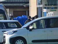 A trap that apparently captured the bear is seen covered with a blue sheet, rear, in the city of Akita on Dec. 2, 2024. (Mainichi/Akira Kudo)