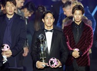 Vissel Kobe football player Yoshinori Muto, center, holds the trophy after being named the winner of the J-League's most valuable player award in a ceremony at Yokohama Arena on Dec. 10, 2024. (Kyodo)