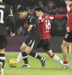 Liverpool's Wataru Endo, left, vies for the ball with Southampton's Yukinari Sugawara during the second half of an English League Cup quarterfinal at St. Mary's Stadium in Southampton, England, on Dec. 18, 2024. (Kyodo)