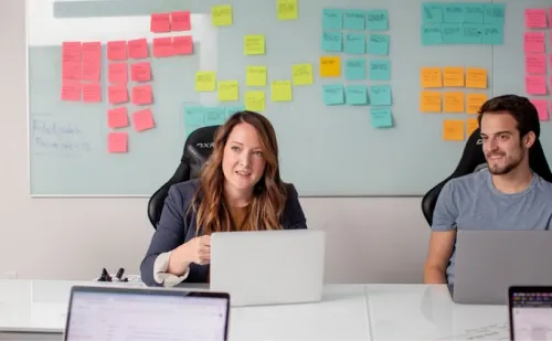 Migration - A picture of staff working together in front of a whiteboard with sticky notes