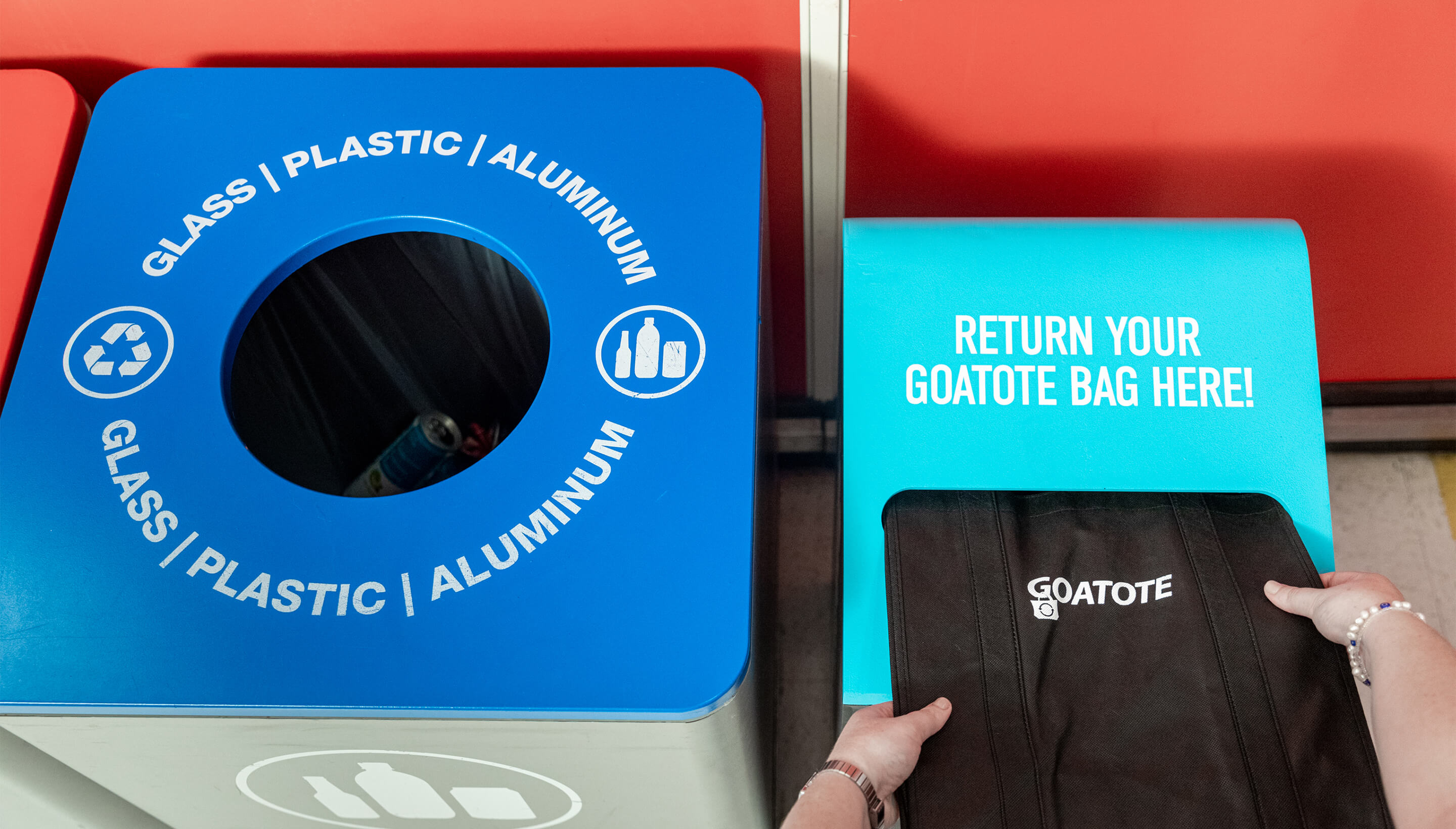 Customer removing a reusable tote bag from the Goatote kiosk