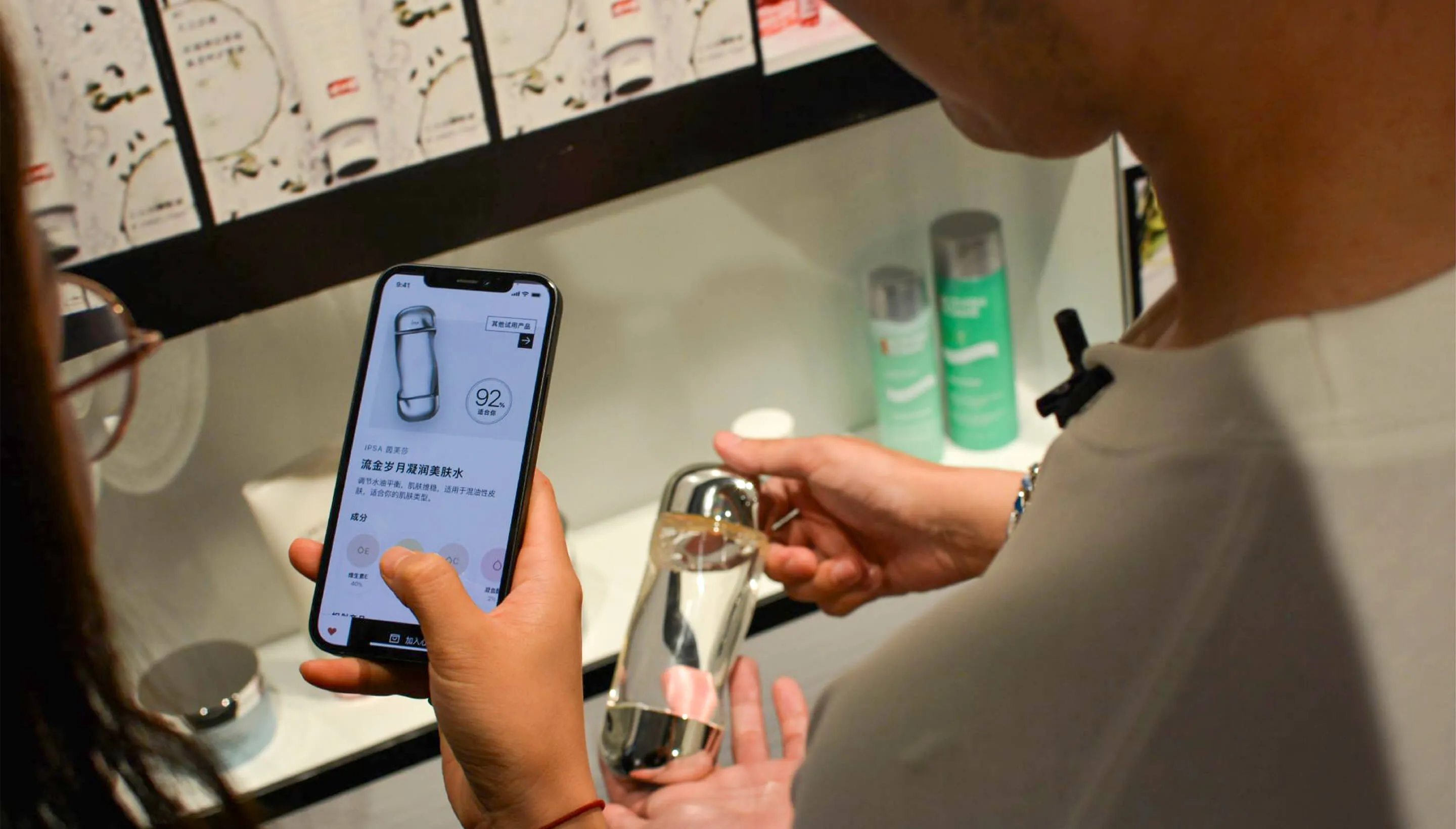 A person scans a perfume bottle with their phone in this cashless Sephora store
