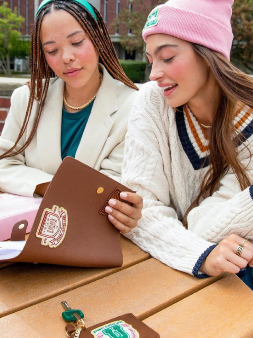 Two women sitting at a table with a Stoney Clover Lane binder open