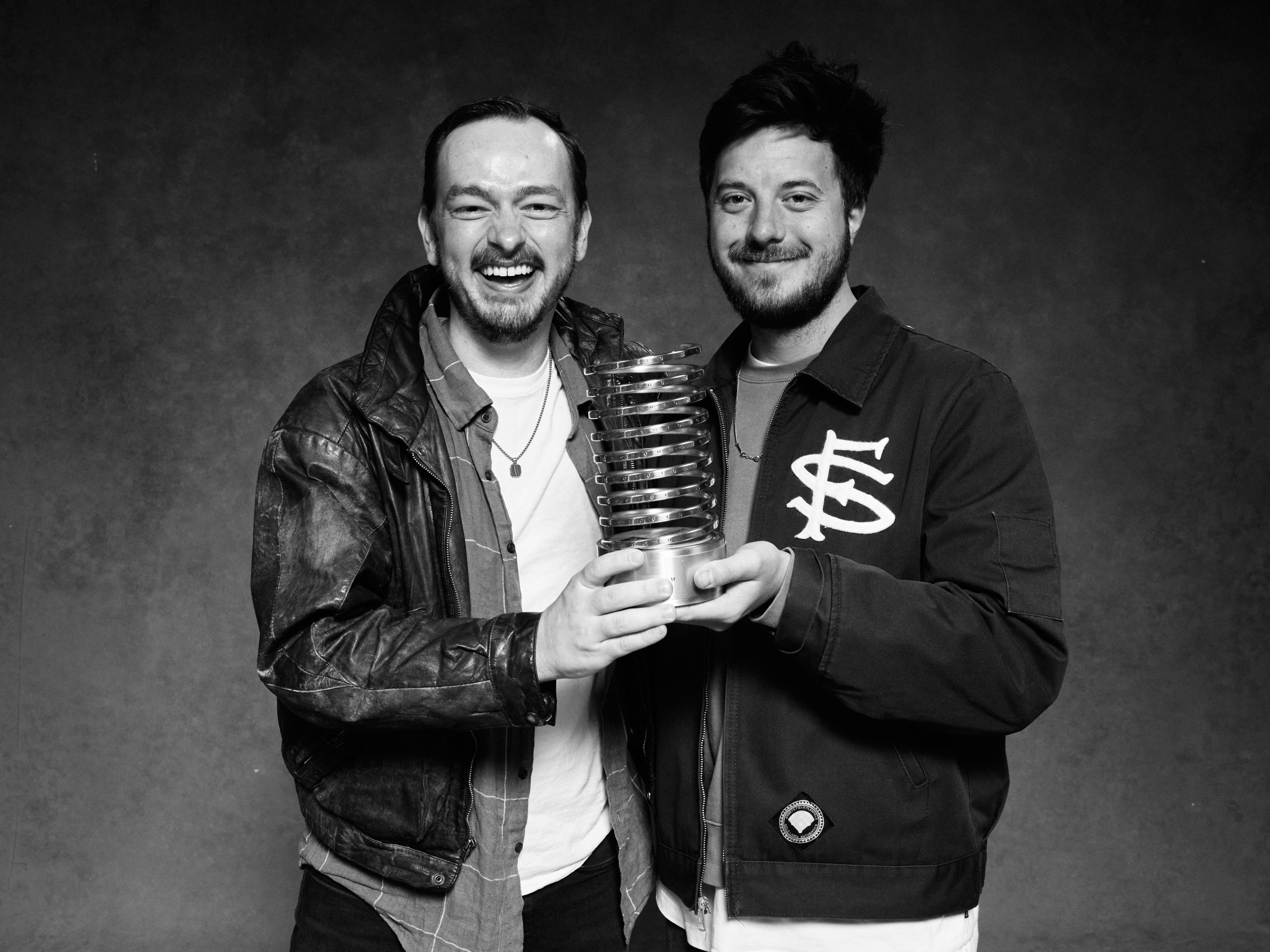 Black and white photo of Trey and Joel on our team, holding our Webby Award at the award ceremony.