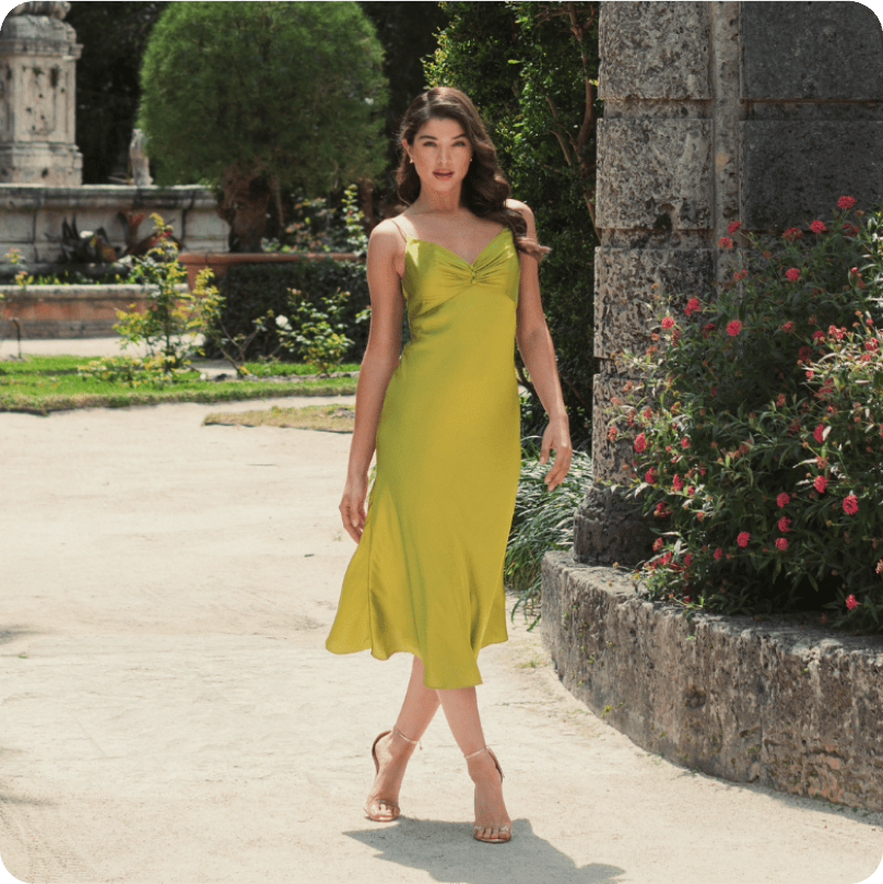 Woman in a green silk dress walking in a garden