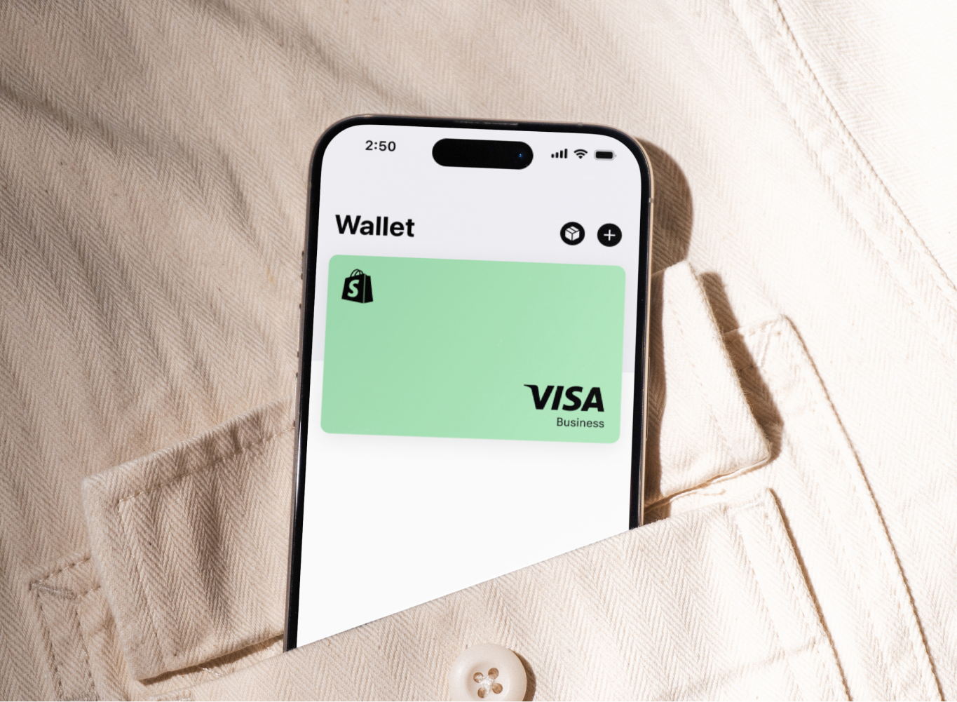 A iPhone sticking out of the top of a pocket, with a digital Shopify Visa credit card on the screen.