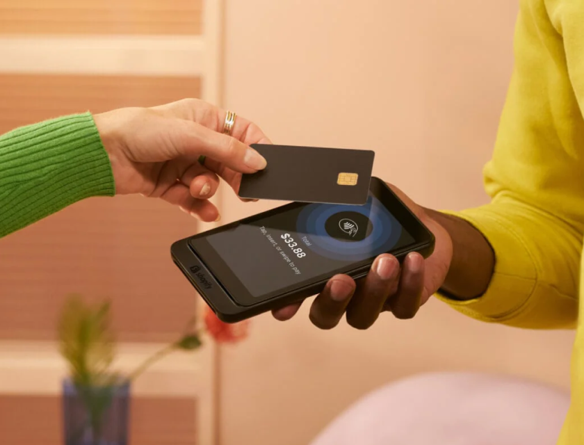 一位客户在 Shopify 的 POS Go 上轻触信用卡来完成购买。