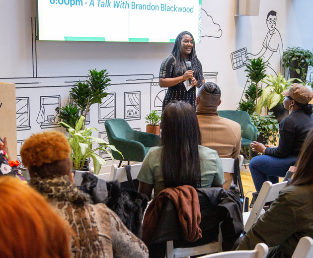 A Build Black Community event close-up photo of a presenter imparting hard-earned learnings to aspiring Black entrepreneurs.